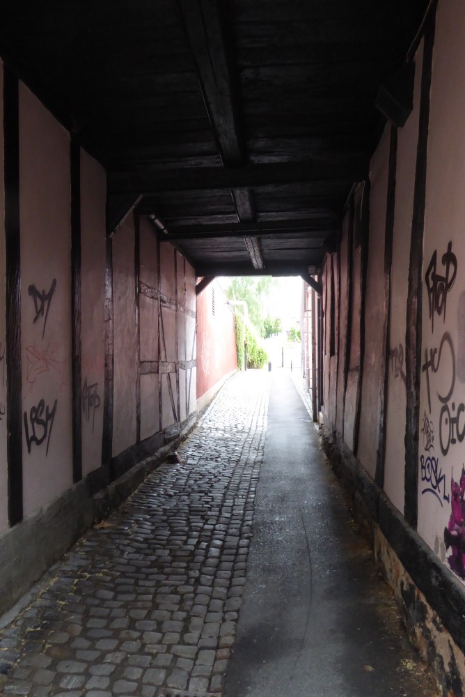Ungefähr eine Etage hoher Durchgang oder Durchfahrt zwischen zwei Fachwerkwänden. Oben ist eine Holzbalkendecke. Der Tunnel ist mindestens acht Gefache lang. Der Weg ist auf der linken Seite mit Kopfsteinpflaster gepflastert und auf der rechten asphaltiert.